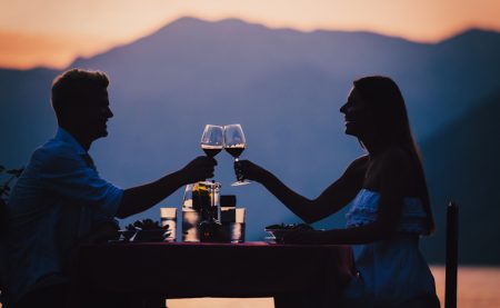 Happy young couple on summer evening having romantic dinner outdoor