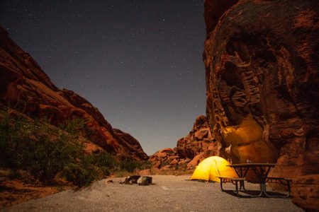 Night shot of Yellow tent pinched in red sandstone campsite in Nevada USA